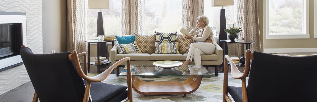 Women reading a book on a couch in her home.
